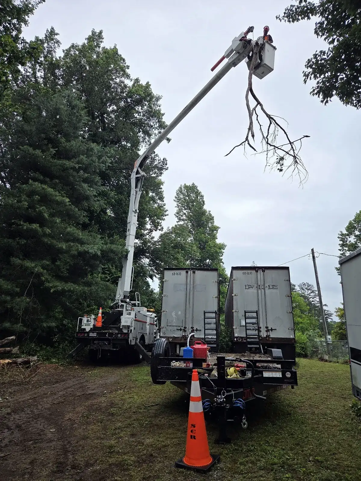 Bucket truck and flatbed trailer staged on site